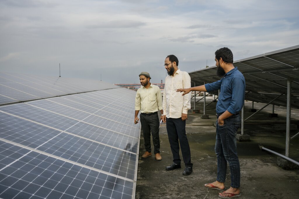 A POTS consultant with a local factory team inspecting a newly installed solar installation.
